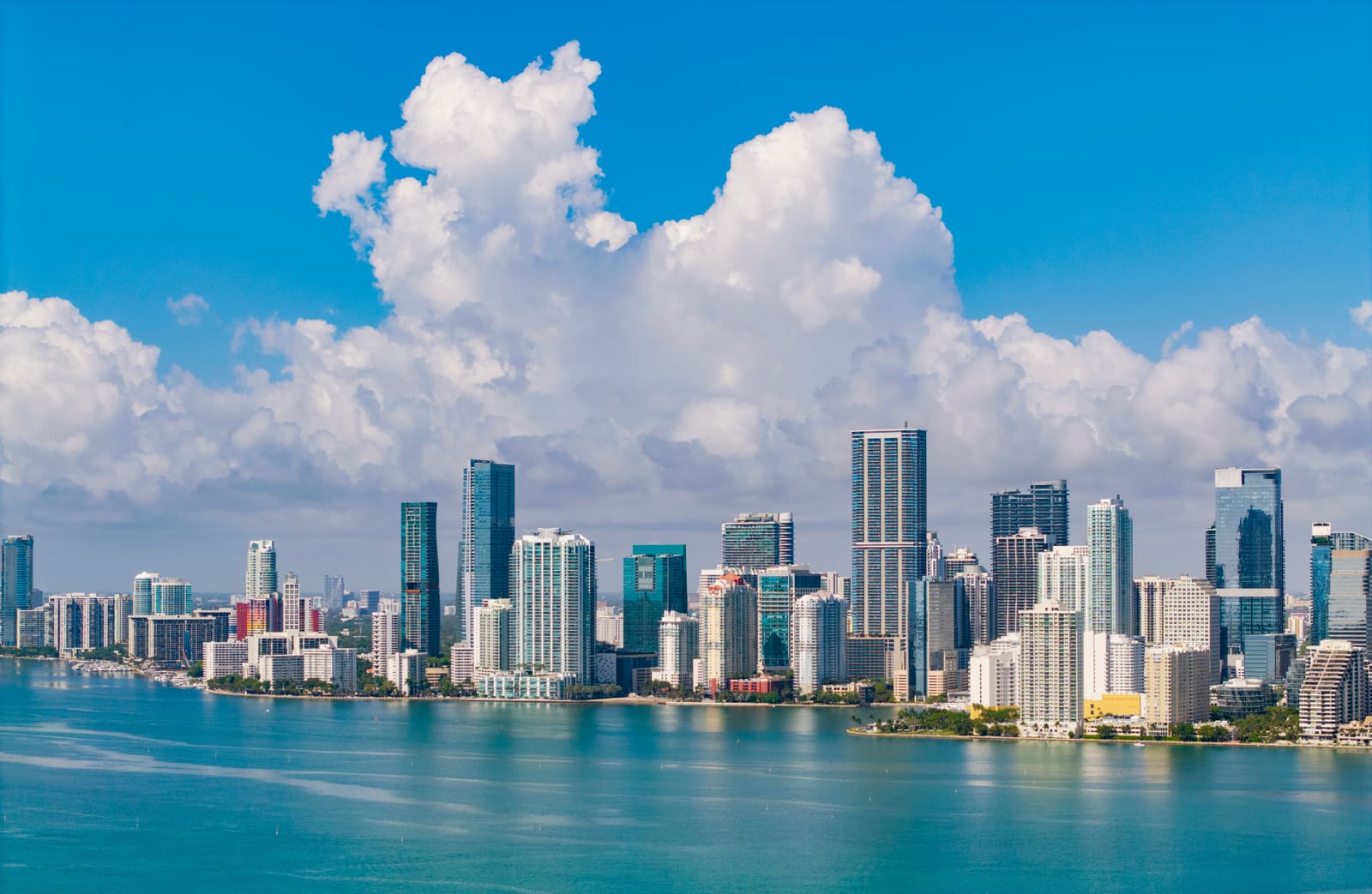 Los rascacielos de Brickell, en Miami, sobre las aguas turquesa de la bahía de Biscayne bajo grandes nubes